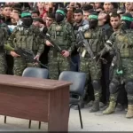 ظهور عناصر مسلحة من كتائب القسام تقف خلف طاولة وكرسيين فارغين - 19 - سيناء الإخبارية